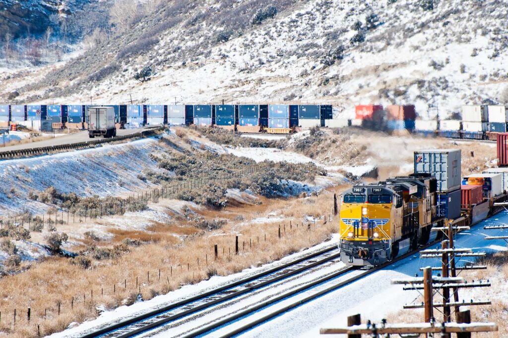 Güterzug in den USA mit Schnee und Trucks – Industriefoto